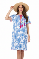 Brunette model in palm print kaftan on plain background