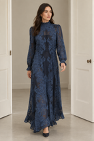 Brunette model wearing the dress and walking through plain doors